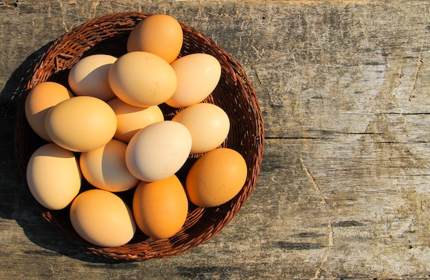 Huevos en canasta de mimbre sobre mesa de madera