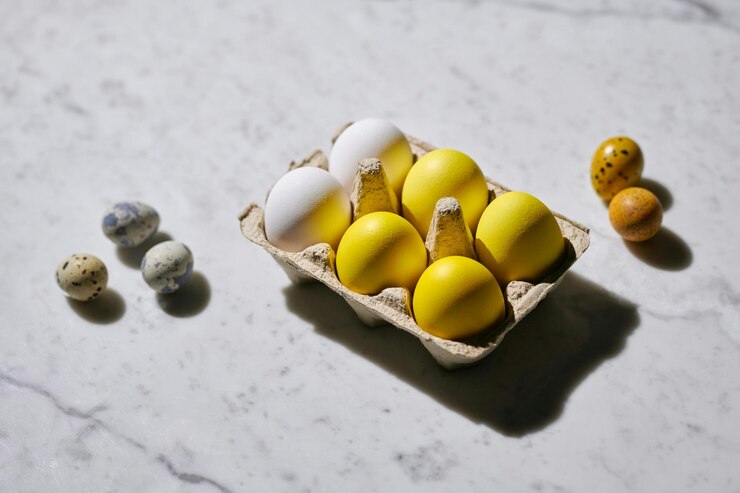 Huevos en cartón de colores amarillo y blanco