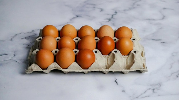 Foto huevos en cartón de huevos sobre mesa de mármol