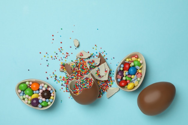 Huevos de chocolate de Pascua con chispas y dulces en azul