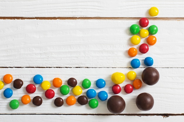 Huevos de chocolate de Pascua y dulces en la superficie de madera blanca