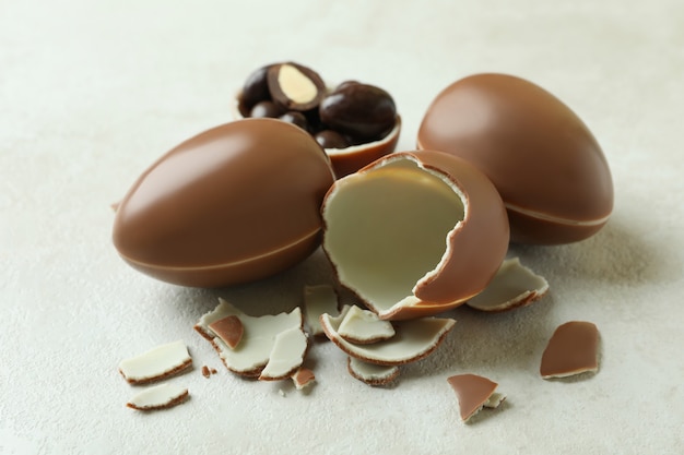 Huevos de chocolate de Pascua en mesa de madera blanca
