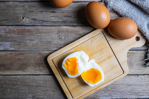 Huevos cocidos y huevos crudos en una mesa de madera.