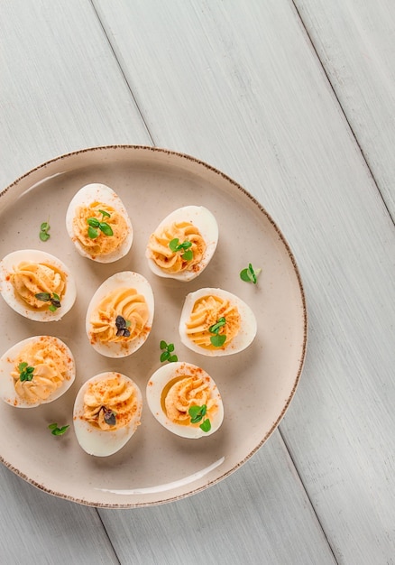 Huevos cocidos rellenos de yema con mayonesa en un plato blanco enfoque selectivo primer plano borroso sin gente