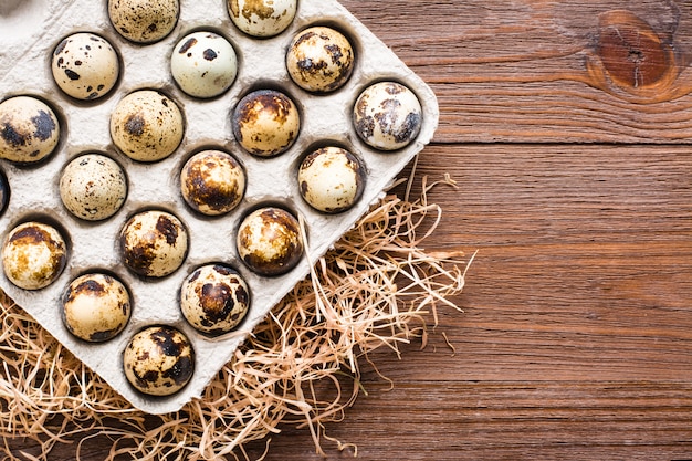 Huevos de codorniz en una caja sobre una mesa de madera