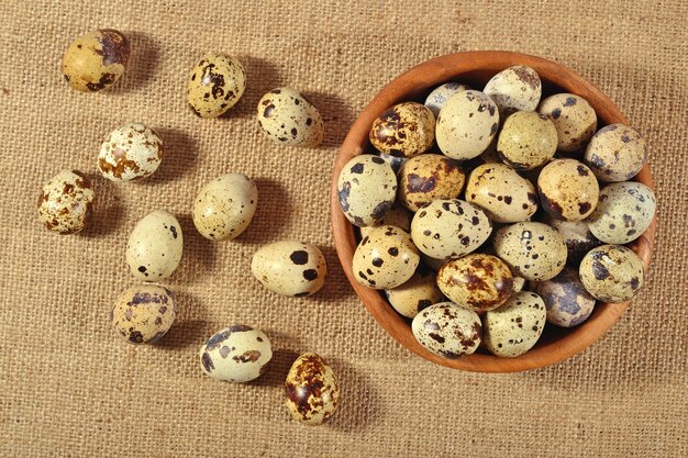 Huevos de codorniz en un cuenco de madera en un fondo de saqueo