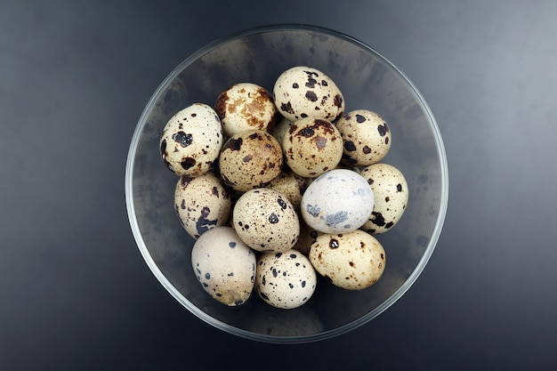 Los huevos de codorniz se encuentran en un plato sobre un fondo oscuro