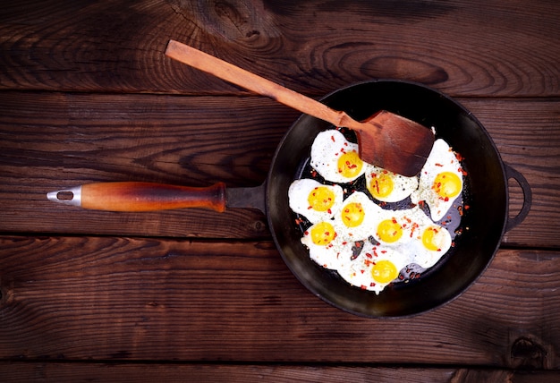 Foto huevos de codorniz fritos en una sartén negra