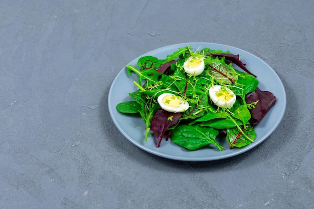 Huevos de codorniz hervidos en una hoja de lechuga con brotes microverdes El concepto de nutrición adecuada Comida vegana Lugar para una inscripción