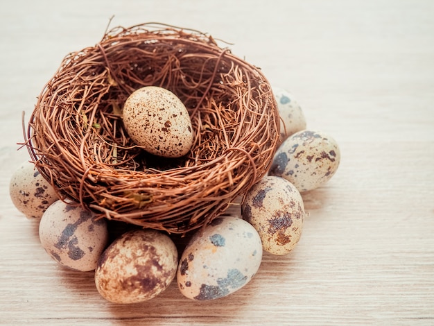 Huevos de codorniz en un nido sobre un fondo de madera