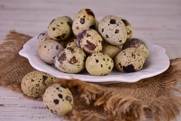 Huevos de codorniz en un plato sobre una mesa de arpillera