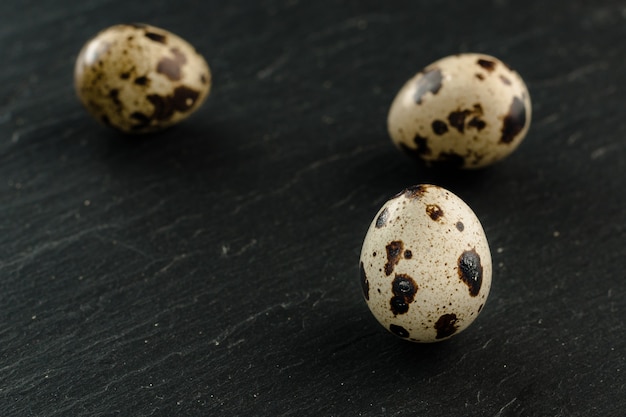 Huevos de codorniz sobre fondo de piedra negra. Producto organico.
