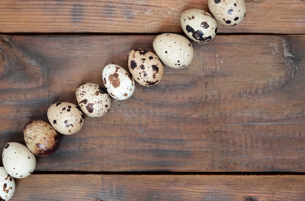 Huevos de codorniz sobre una superficie de madera marrón oscuro, vista desde arriba, lugar vacío para el texto, receta