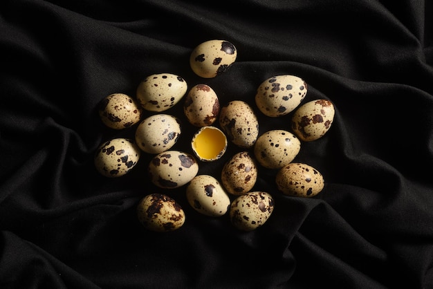 Huevos de codorniz en un trozo de tela negra Primer plano