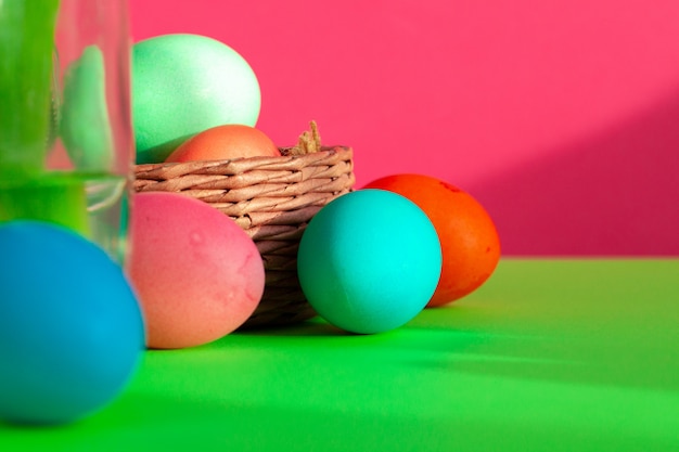 Huevos de colores vibrantes en un nido en verde. Concepto de pascua