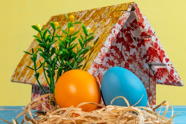 Foto huevos coloridos que simbolizan la pascua con una casa de juguetes flores como un jardín