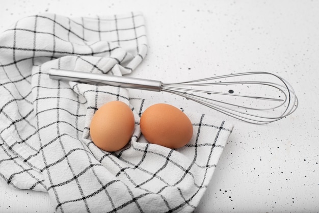 Huevos una corola y un paño de cocina sobre un fondo claro