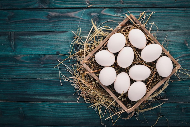 Huevos crudos de pollo en una cesta de madera Sobre un fondo de madera Vista superior Espacio de copia