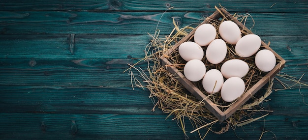 Huevos crudos de pollo en una cesta de madera Sobre un fondo de madera Vista superior Espacio de copia