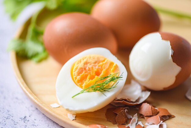 Foto huevos desayuno huevos frescos descascarados menú comida huevos hervidos en un plato de madera decorado con hojas eneldo verde y cáscara de huevo cortada a la mitad yemas de huevos para cocinar alimentación saludable