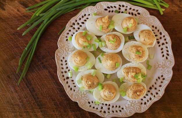 Huevos de diablo con hígado de bacalao con puré en plato blanco mesa de madera rústica