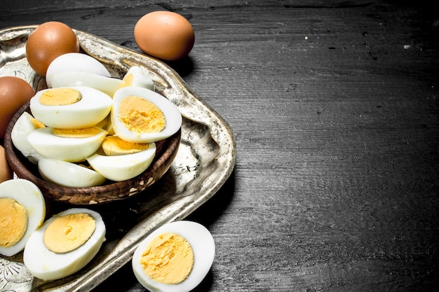 Huevos duros en un recipiente en la pizarra negra