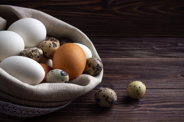 Huevos ecológicos en la servilleta de lino en el fondo de madera