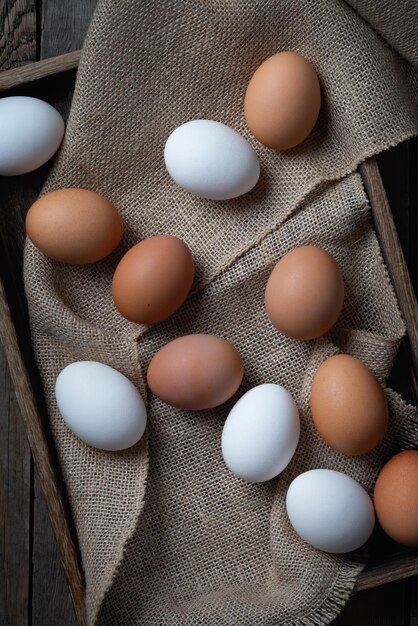 Huevos frescos en una caja sobre una mesa de madera antigua