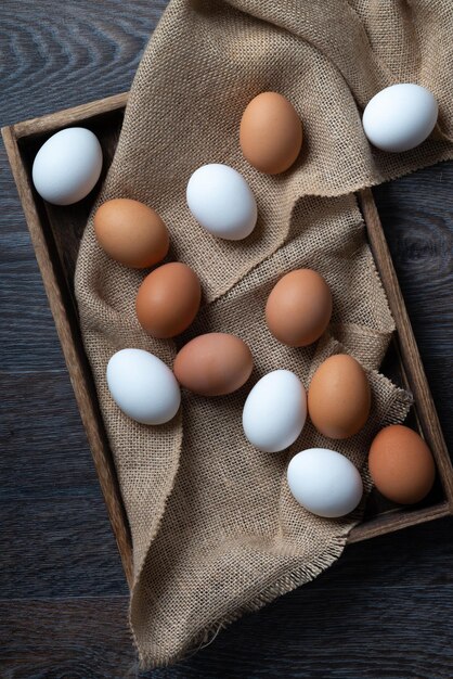 Huevos frescos en una caja sobre una mesa de madera