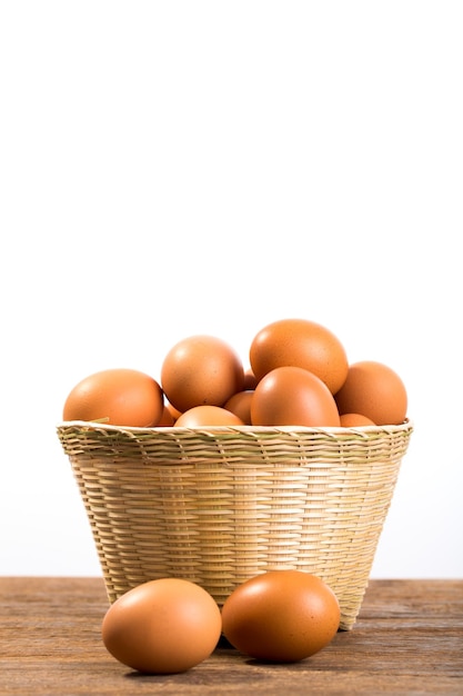 huevos frescos en cesta de bambú sobre fondo blanco