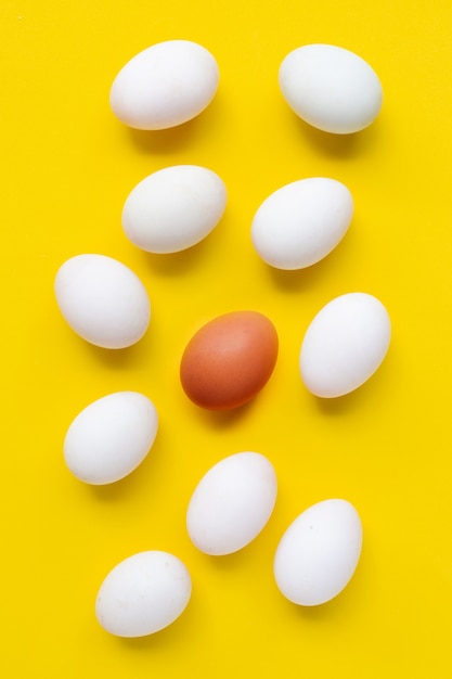 Huevos frescos en superficie amarilla.