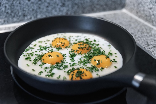 Huevos fritos con cebollas verdes en una sartén