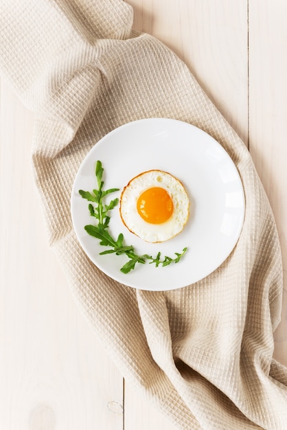 Huevos fritos con rúcula sobre una toalla de lino