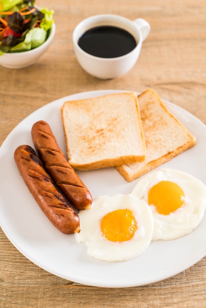 Huevos fritos con salchicha y pan.