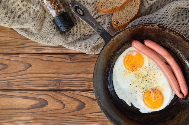 Huevos fritos con salchichas en una sartén