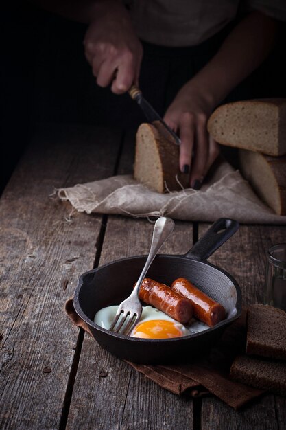 Huevos fritos con salchichas en una sartén.