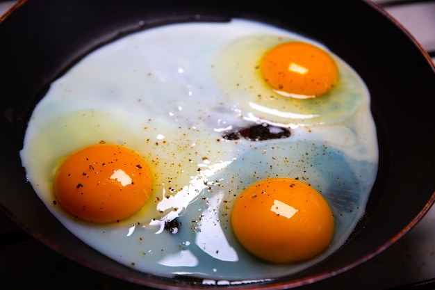 Huevos fritos en la sartén. Yemas de naranja ecológicas. idea de desayuno.