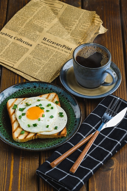 Huevos fritos sobre tostadas con café caliente