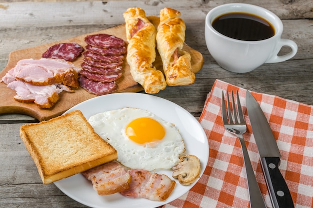 Huevos fritos, tocino y café, delicioso desayuno.