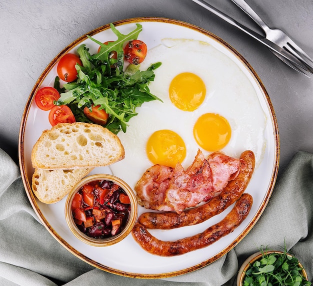 Huevos fritos y tocino para desayunar en un plato