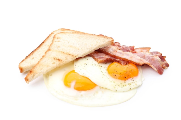 Huevos fritos, tocino y tostadas aislado sobre fondo blanco.