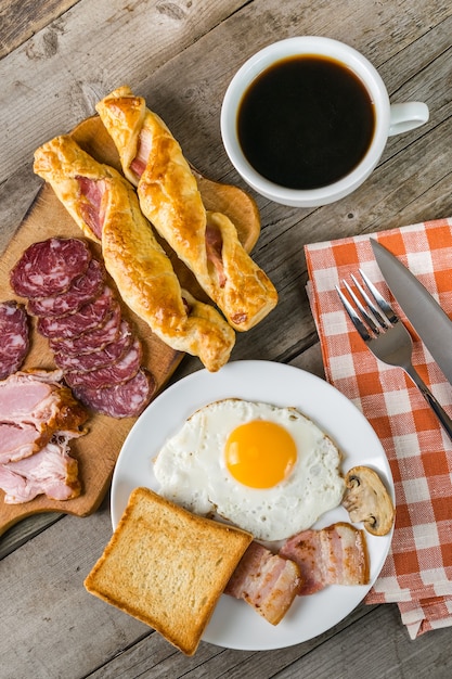 Huevos fritos, tocino y tostadas, delicioso desayuno.