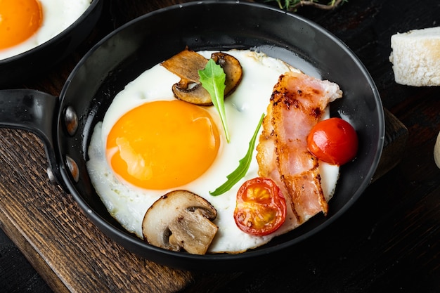 Huevos fritos con tocino y verduras en una sartén de hierro fundido