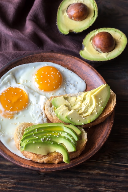 Huevos fritos con tostadas y aguacate.