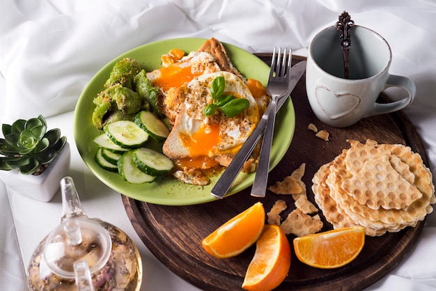 Foto huevos fritos con tostadas y té en la cama.