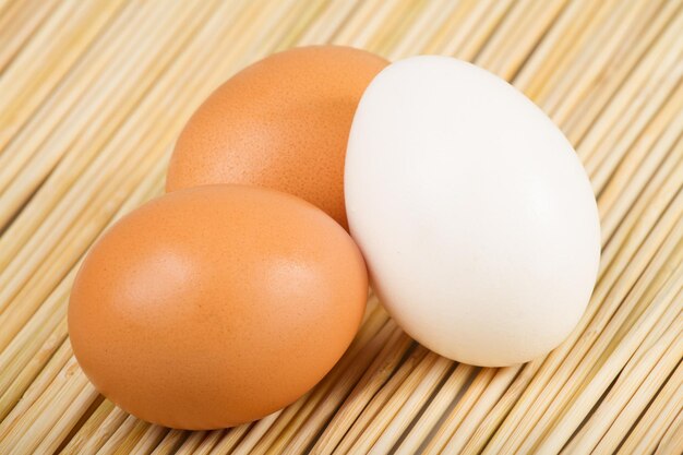 Huevos de gallina apilados en la mesa de madera