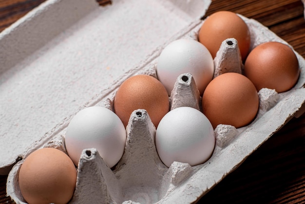 Huevos de gallina en una bandeja marrón y blanca.