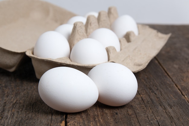 Huevos de gallina blanca en una caja de cartón