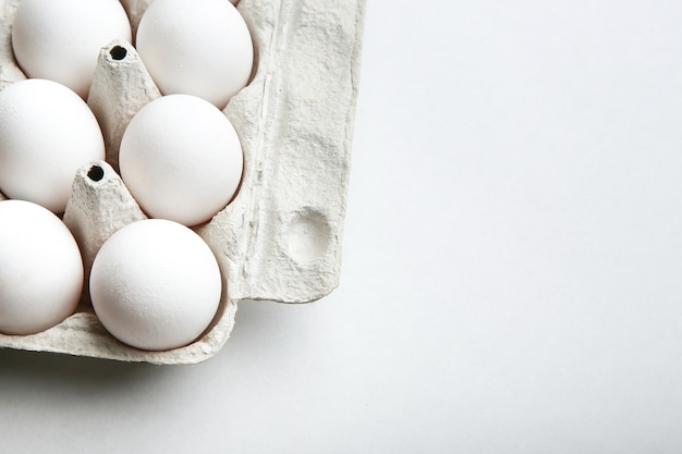 Huevos de gallina blanca en una caja de huevos