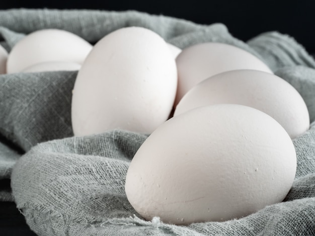 Huevos de gallina blanca sobre una tela de lino claro.